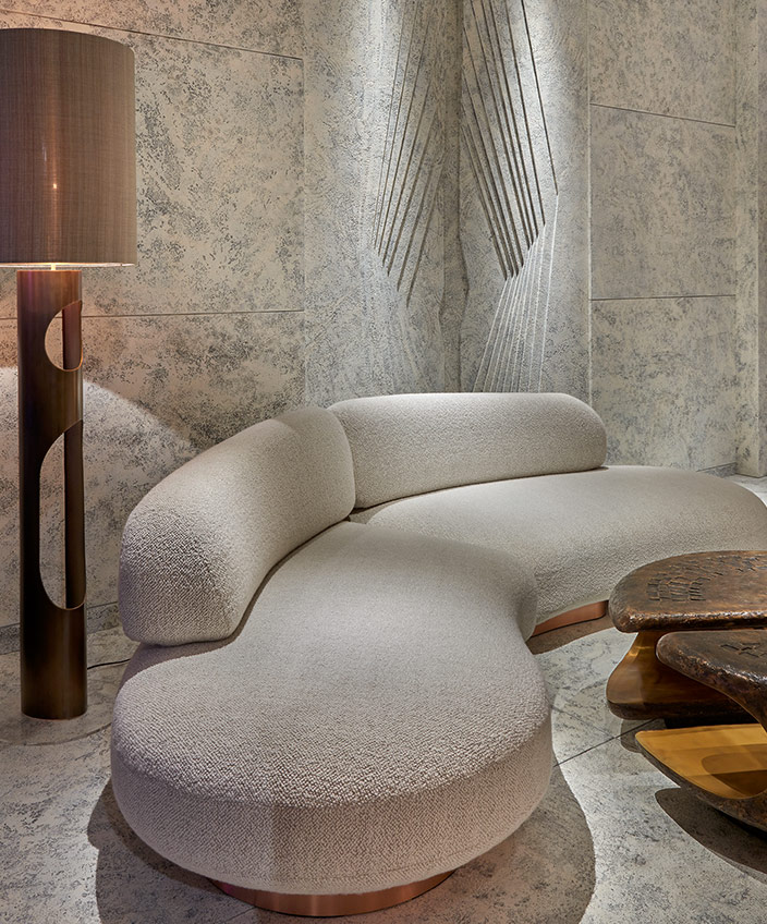 Thierry Lemaire - French interior designer - Sofa ecru in roundness - Bronze floor lamp - Exhibition Pad Paris 2019 - Hammered bronze coffee table - Marble wall - Signatures Singulières - Magazine of French know-how - French know-how